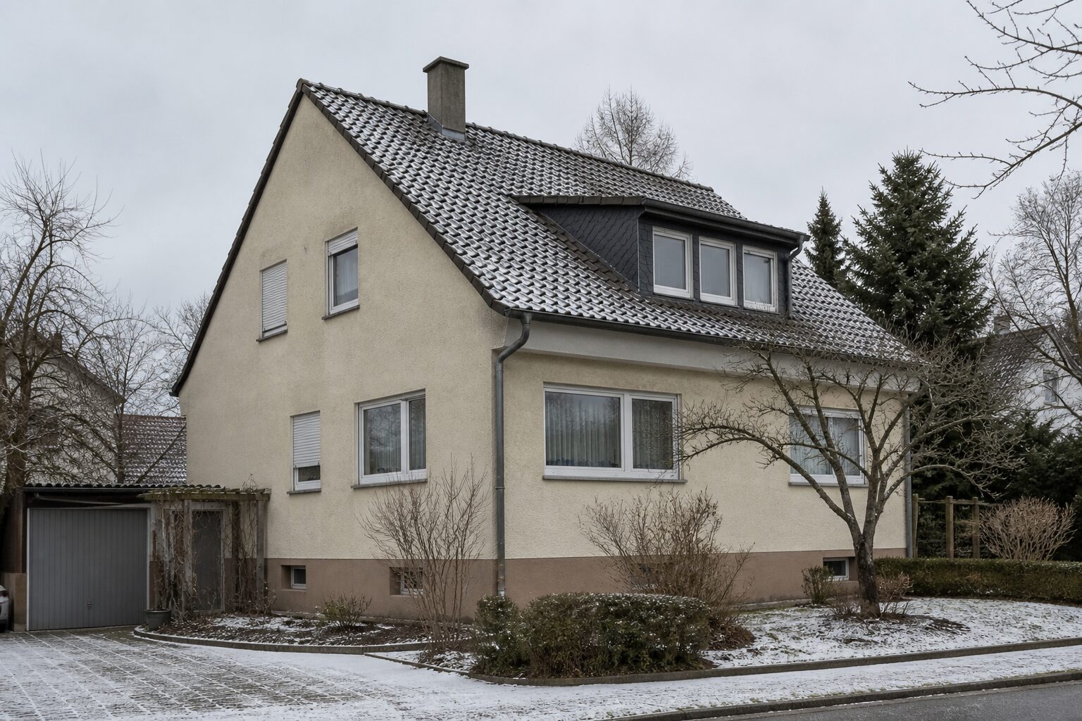 Freistehendes Wohnhaus aus den 1970er Jahren mit alten Fenstern an einem Wintertag