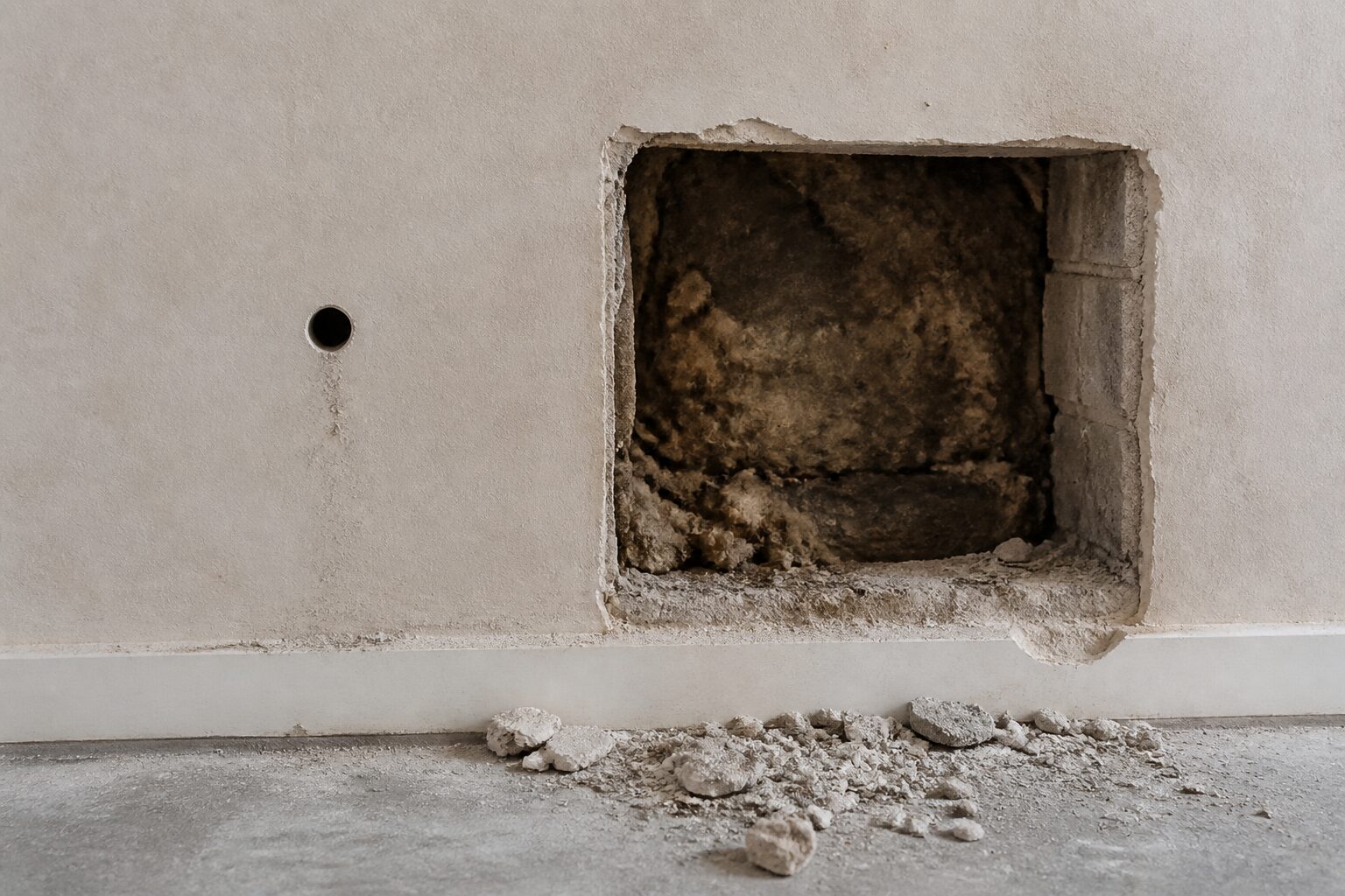 Innenwand mit einem kleinen Bohrloch links und einer großen rechteckigen Bauteilöffnung daneben